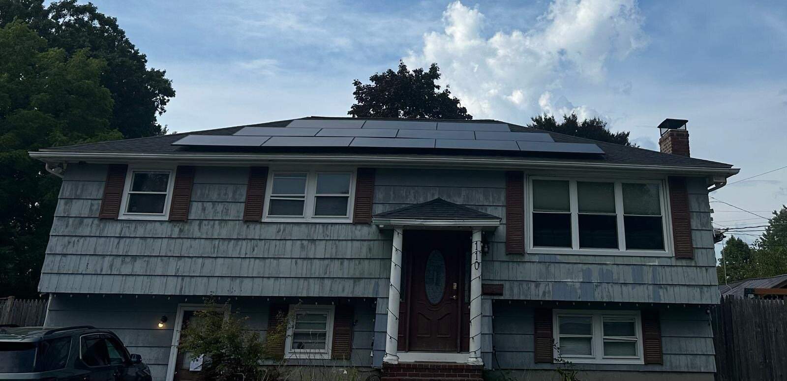 Solar-powered home with rooftop solar panels, residential house with multiple solar panels installed on the roof, energy-efficient home harnessing solar energy, modern house emphasizing eco-friendly energy solutions, relevance.