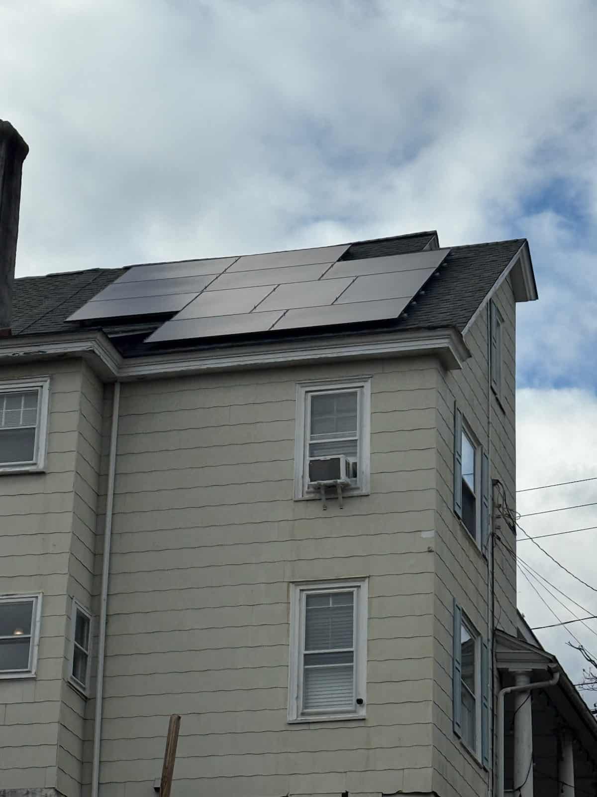 Close-up of a two-story home with rooftop solar panels installed on an asphalt shingle roof, highlighting residential solar installation, clean energy upgrades, and long-term solar savings for homeowners.