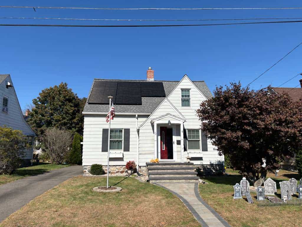 Single-family New England home with rooftop solar panels, highlighting residential solar installation, clean energy savings, and reduced electricity costs for homeowners.
