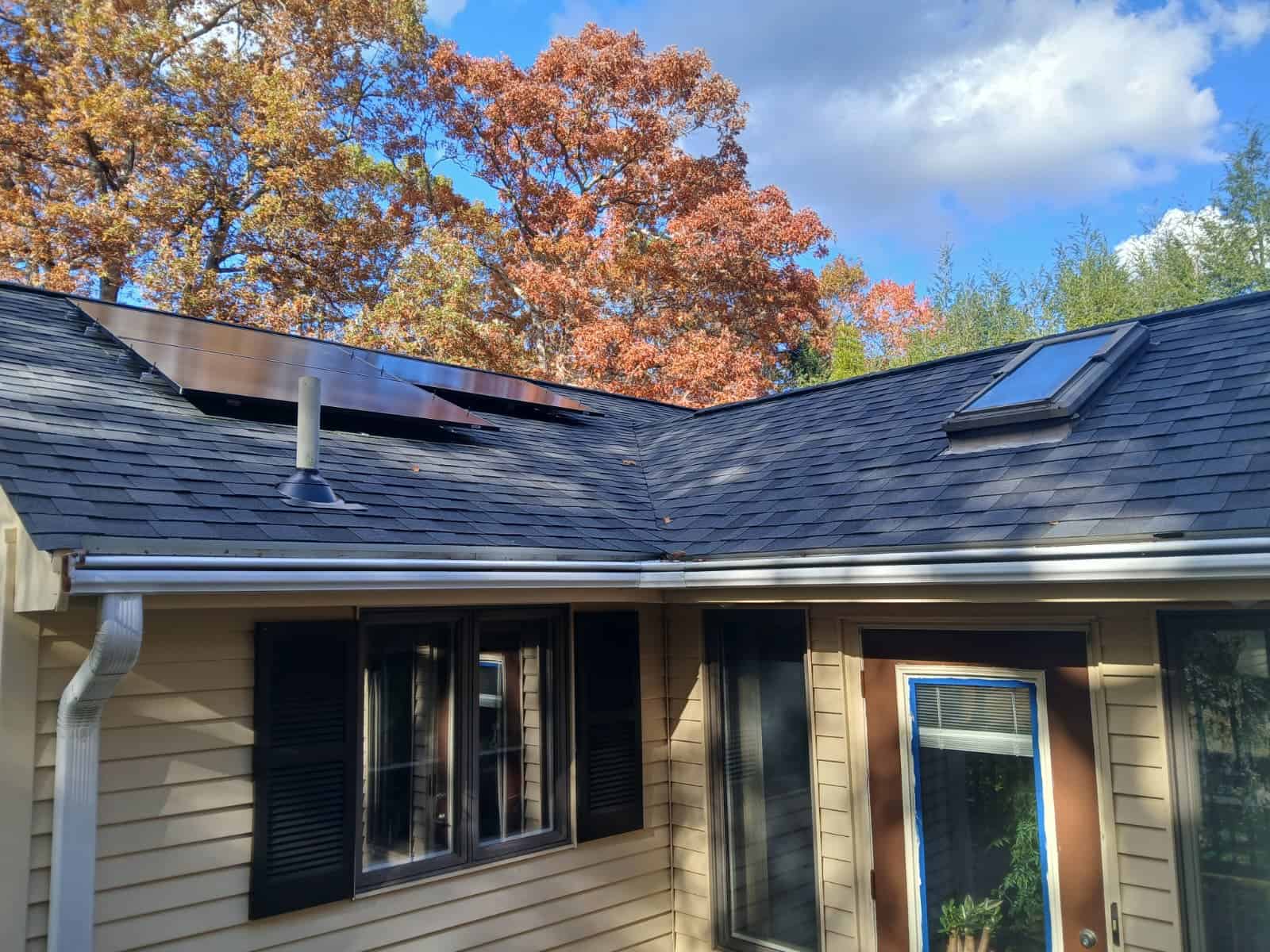 Residential home with roof-mounted solar panels integrated into an asphalt shingle roof, showcasing a clean solar installation designed to lower electricity bills, improve energy efficiency, and maximize long-term solar savings for a New England homeowner.