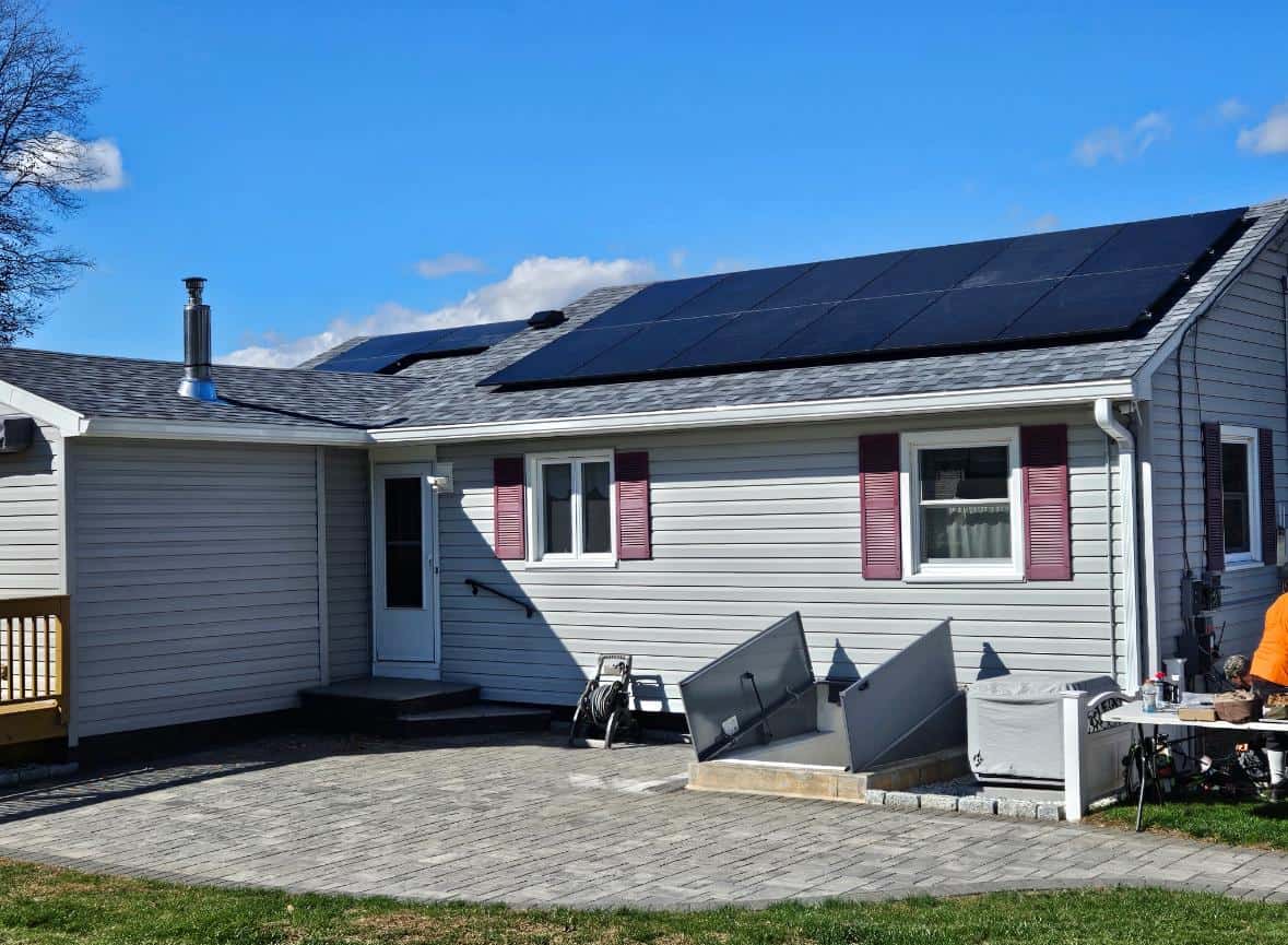 Rear exterior of a single-story home with rooftop solar panels installed, highlighting residential solar energy, lower electric bills, and long-term solar savings for homeowners.