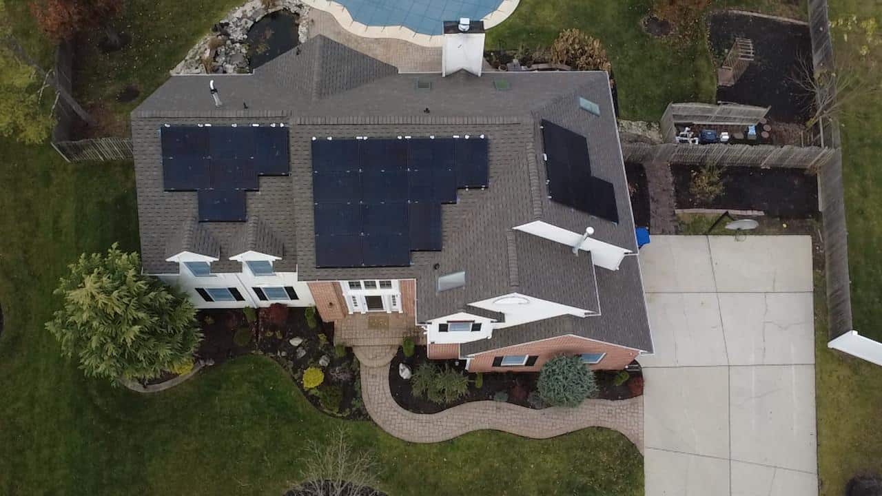 Aerial top-down view of a residential home with a multi-array rooftop solar installation, carefully designed around rooflines and obstructions to maximize solar production while maintaining a clean, balanced layout suited for a New England property.